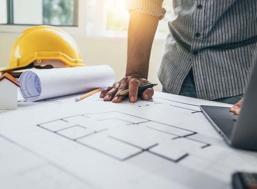 Blueprints of designer and engineers working at architects office desk.